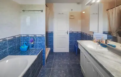 a blue tiled bathroom with two sinks and a tub at Pet Friendly Home In Saint Chinian With Wifi in Saint-Chinian