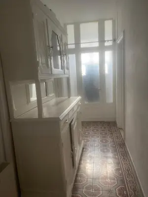 a kitchen with white cabinets and a tile floor at Apartment for 2 in Embres in Embres-et-Castelmaure