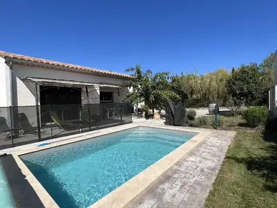 a swimming pool in front of a house at Villa la garrigue in Boutenac