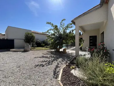 a house with a gravel driveway next to a building at Villa la garrigue in Boutenac