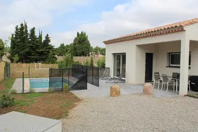 a backyard of a house with a pool and a fence at Villa la garrigue in Boutenac