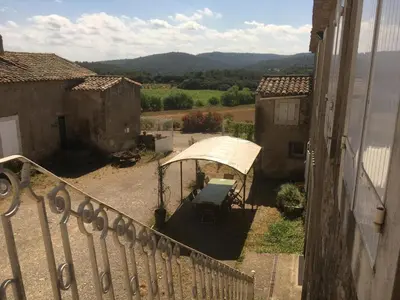 a balcony with a table and an umbrella at Chateau st-auriol - le caviste in Lagrasse