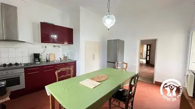a kitchen with a table and a green table and chairs at Chateau st-auriol - le caviste in Lagrasse