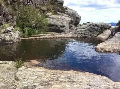 a body of water with rocks and a mountain at Maison accueillante à Le Soulié avec jardin in Le Soulié