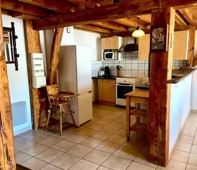 a kitchen with a white refrigerator and a table at Maison accueillante à Le Soulié avec jardin in Le Soulié