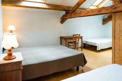 a bedroom with two beds and a table and a chair at Maison accueillante à Le Soulié avec jardin in Le Soulié