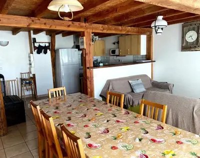 a dining room with a table and a kitchen at Maison accueillante à Le Soulié avec jardin in Le Soulié