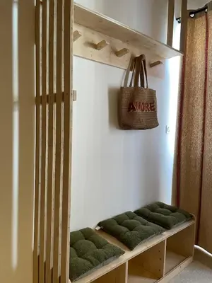 a room with a bench with green cushions at Petite maison au centre de Mirepoix in Mirepoix