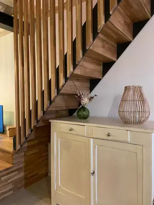 a room with a wooden staircase with a table and a vase at Petite maison au centre de Mirepoix in Mirepoix
