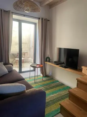 a living room with a couch and a flat screen tv at Petite maison au centre de Mirepoix in Mirepoix
