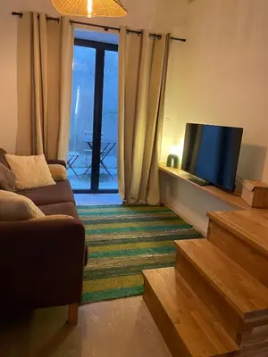 a living room with a couch and a flat screen tv at Petite maison au centre de Mirepoix in Mirepoix