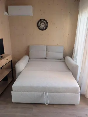 a bed in a room with a clock on the wall at Localodge in Caves