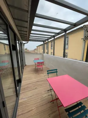 a patio with tables and chairs on a building at Maison de ville rénovée - Carc'apparts - terrasse in Carcassonne