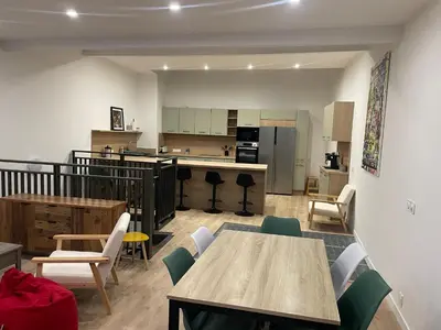 a living room with tables and chairs and a kitchen at Maison de ville rénovée - Carc'apparts - terrasse in Carcassonne