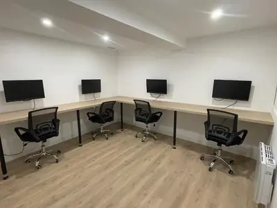 a room with four desks with monitors and chairs at Maison de ville rénovée - Carc'apparts - terrasse in Carcassonne