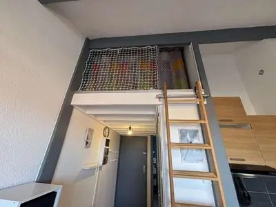 a loft bed in a room with a ladder at Appartement Studio Cabine Mezzanine 4 couchages- PORT-LA NOUVELLE PN290-031 in Port-la-Nouvelle