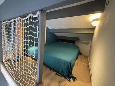 a bed in a tiny house with a net at Appartement Studio Cabine Mezzanine 4 couchages- PORT-LA NOUVELLE PN290-031 in Port-la-Nouvelle