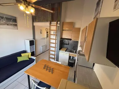 a small room with a kitchen and a dining table at Appartement Studio Cabine Mezzanine 4 couchages- PORT-LA NOUVELLE PN290-031 in Port-la-Nouvelle