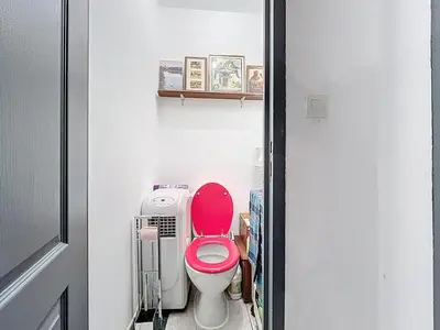 a bathroom with a pink toilet in a room at Le poli - 6 pers - Centre - vue sur la cathédrale in Narbonne