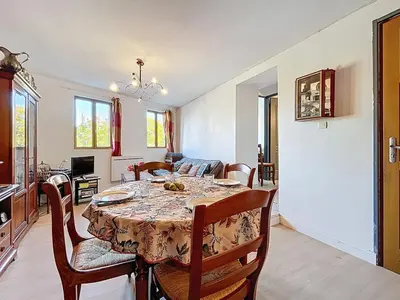 a dining room with a table and some chairs at Le poli - 6 pers - Centre - vue sur la cathédrale in Narbonne