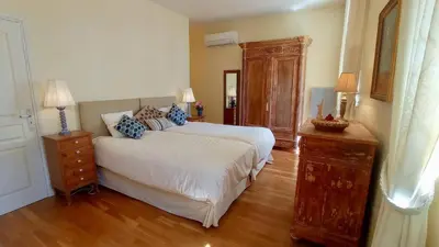 a bedroom with a large bed and a wooden floor at Gite Charles de Castres in Saint-Affrique-les-Montagnes