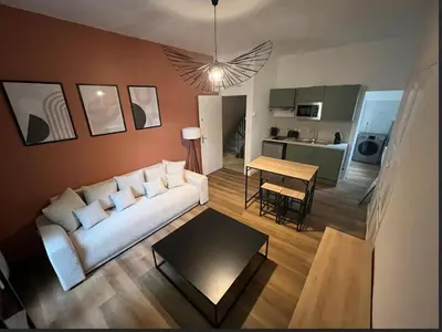 a living room with a white couch and a table at Studio, centre-ville Narbonne in Narbonne