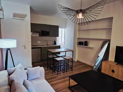 a living room with a couch and a table and a kitchen at Studio, centre-ville Narbonne in Narbonne