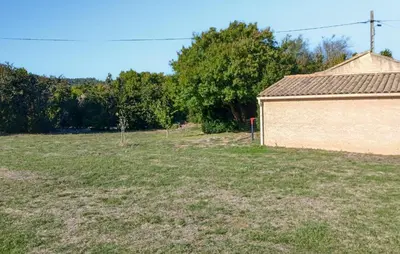 a large field with a building and trees in the background at 2 Bedroom Awesome Home In Pardailhan in Pardailhan