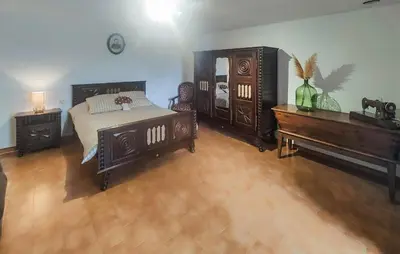 a bedroom with a bed and a dresser and a piano at 2 Bedroom Awesome Home In Pardailhan in Pardailhan