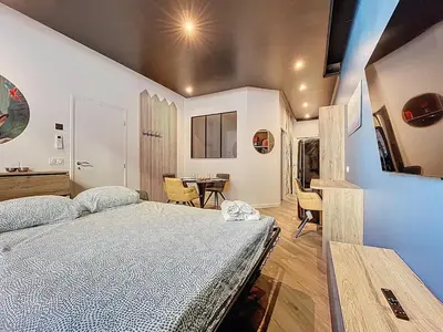 a bedroom with a bed and a table with chairs at la loge des halles - clim - 50m des halles in Narbonne