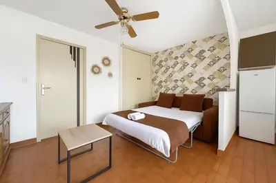 a bedroom with a bed and a ceiling fan at Studio Cabine En Bord De Mer à Gruissan in Gruissan