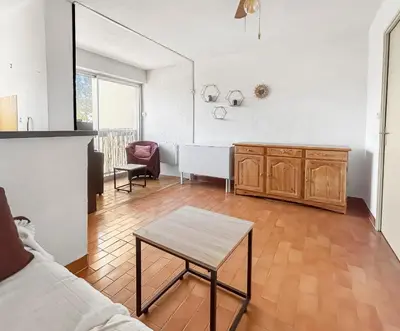 a living room with a couch and a table at Studio Cabine En Bord De Mer à Gruissan in Gruissan