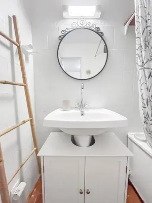 a white bathroom with a sink and a mirror at Studio Cabine En Bord De Mer à Gruissan in Gruissan
