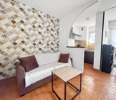 a living room with a couch and a table at Studio Cabine En Bord De Mer à Gruissan in Gruissan