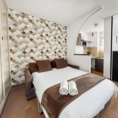 a bedroom with a large white bed with towels on it at Studio Cabine En Bord De Mer à Gruissan in Gruissan