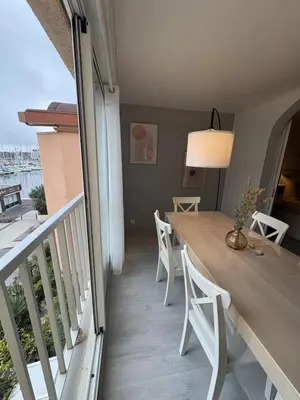 a dining room with a table and chairs on a balcony at Spacieux duplex sur le port in Gruissan
