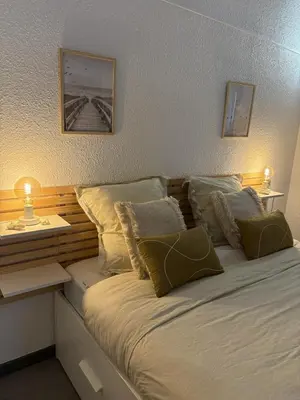 a bedroom with a bed with pillows and a table at Spacieux duplex sur le port in Gruissan