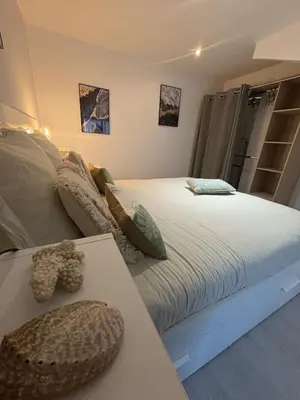 a bedroom with a large white bed and a table at Spacieux duplex sur le port in Gruissan