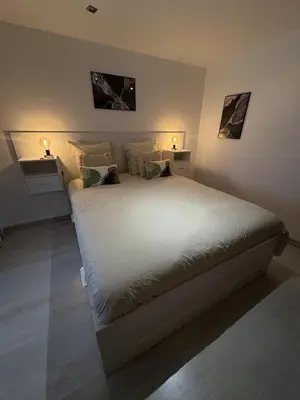 a bedroom with a large white bed with two lamps at Spacieux duplex sur le port in Gruissan