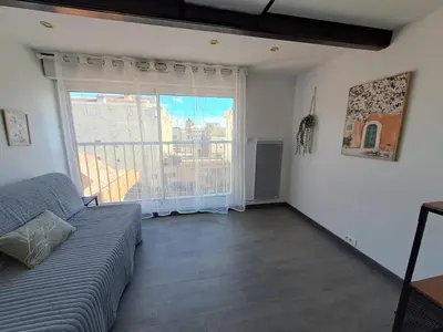 a living room with a couch and a large window at Spacieux duplex sur le port in Gruissan