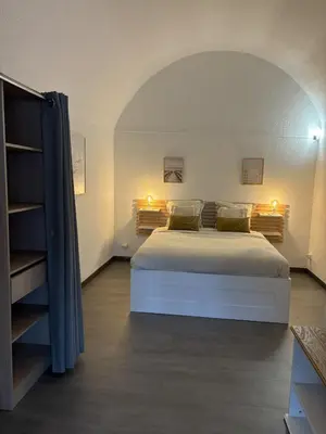 a bedroom with a large bed and a book shelf at Spacieux duplex sur le port in Gruissan