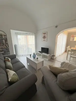 a living room with two couches and a table at Spacieux duplex sur le port in Gruissan