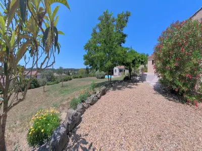 a garden with flowers and trees and a building at Relaxing Retreat Near Minerve in Aigne