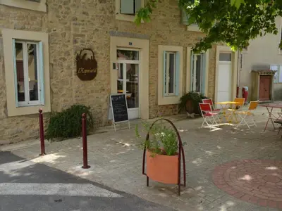 a building with tables and chairs in front of it at Relaxing Retreat Near Minerve in Aigne