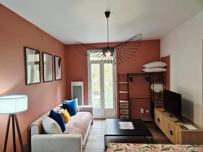 a living room with a couch and a tv at Cosy studio, centre ville Narbonne in Narbonne