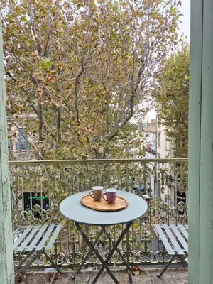 a table with two cups on it on a balcony at Cosy studio, centre ville Narbonne in Narbonne