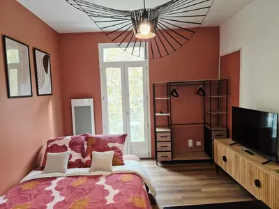 a bedroom with a bed and a flat screen tv at Cosy studio, centre ville Narbonne in Narbonne