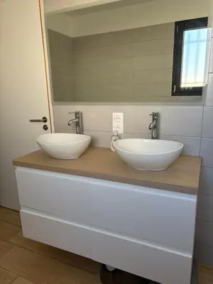 a bathroom with two sinks on a counter with a mirror at La villa du soleil in Lapalme