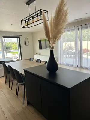 a living room with a table with a vase with feathers in it at La villa du soleil in Lapalme