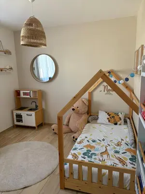 a childs bedroom with a bed with a wooden frame at La villa du soleil in Lapalme